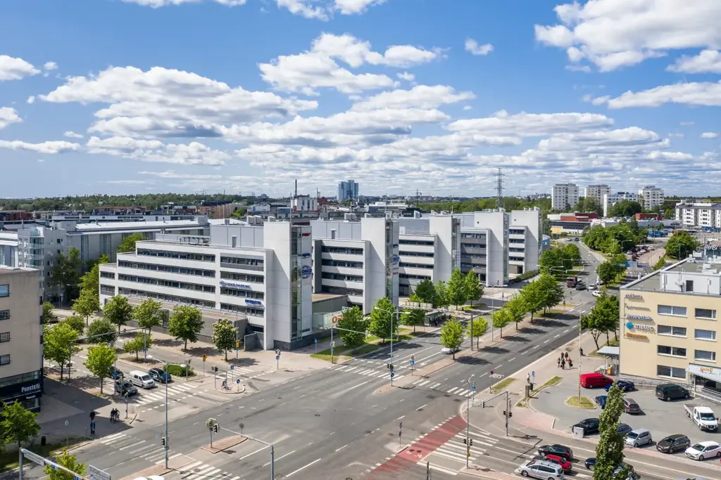 Viiden toimitilakiinteistön kokonaisuus Opus Business Park, etualalla autotie ja ympärillä kerrostaloja ja kaupunkiympäristöä.