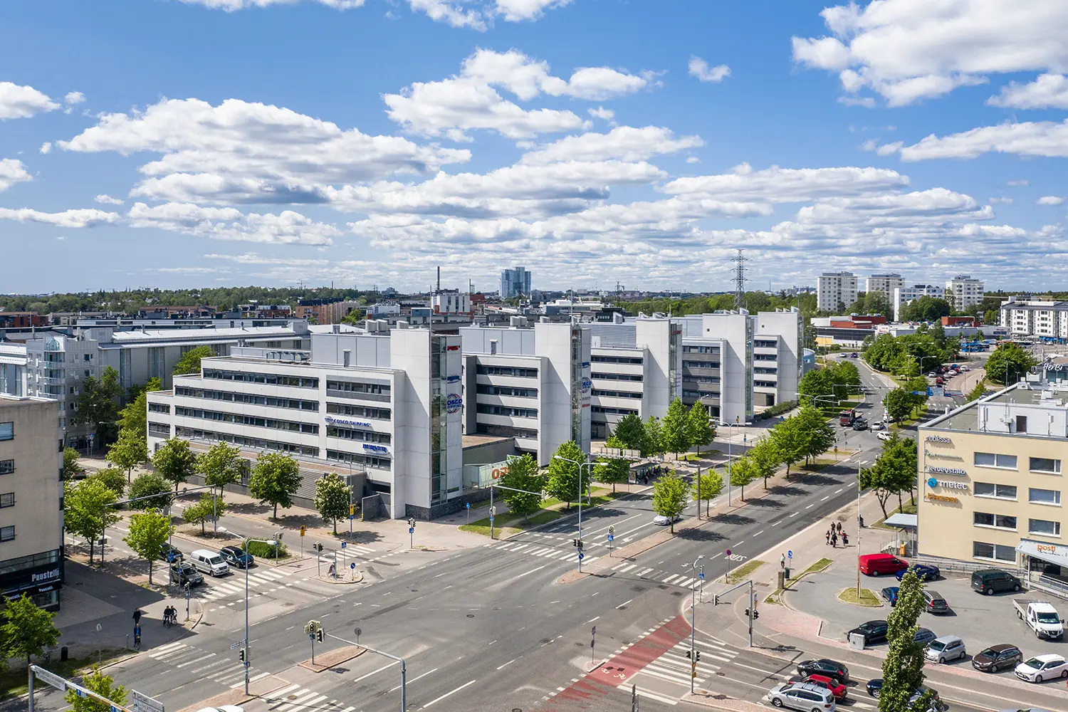 Viiden toimitilakiinteistön kokonaisuus Opus Business Park, etualalla autotie ja ympärillä kerrostaloja ja kaupunkiympäristöä.