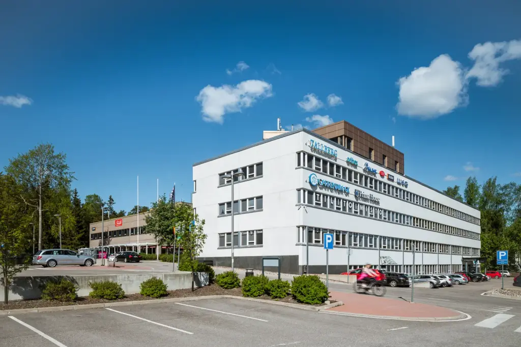 Matala, valkea toimitilakiinteistö, joka takaa näkyy ruskeanharmaa 2-kerroksinen rakennus.