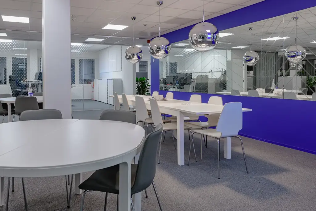 Istumatilaa PRESSI Smart Premises B-talon taukotilasssa. Takana näkyy toimistohuoneita kuvioitujen lasiseinien läpi.